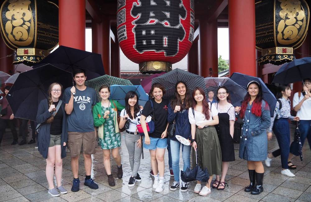 Students pose in front of a temple in Japan. 