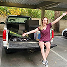 Woman sitting on bed of pickup truck