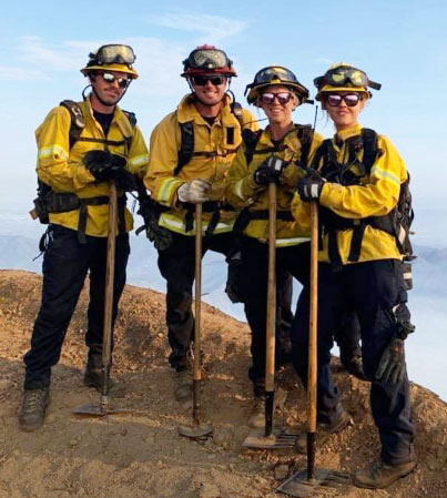 Campus fire crew poses at forest fire.