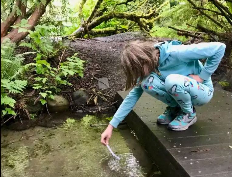 girl tests water quality in creek