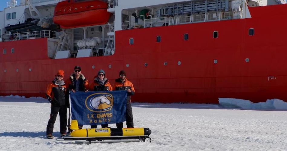 UC Davis doctoral students Cordielyn Goodrich, Andrew Friedrichs and Jasmin McInerney with EPFL’s Sebastian Lavanchy and the glider Storm Petrel on the ice beside icebreaker R/V Araon at Jang Bogo Station in Antarcticain January 2019. (Joe Haxel, OSU/NOAA)