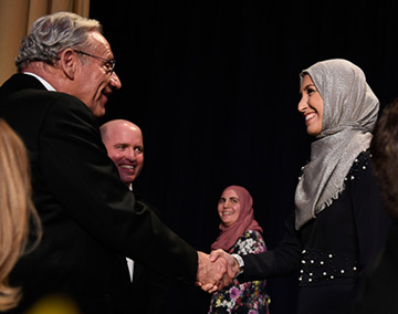Washington Post journalist Bob Woodward shaking UC Davis alumna Sawsan Morrar's hand