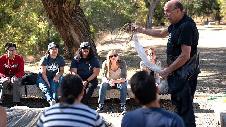 Professor Robert Kimsey addressing a group of students showing them a fish trap