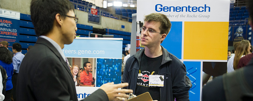 Gordon Magill, right, a Genentech employee and UC Davis alumni, listening to a student at a career fair