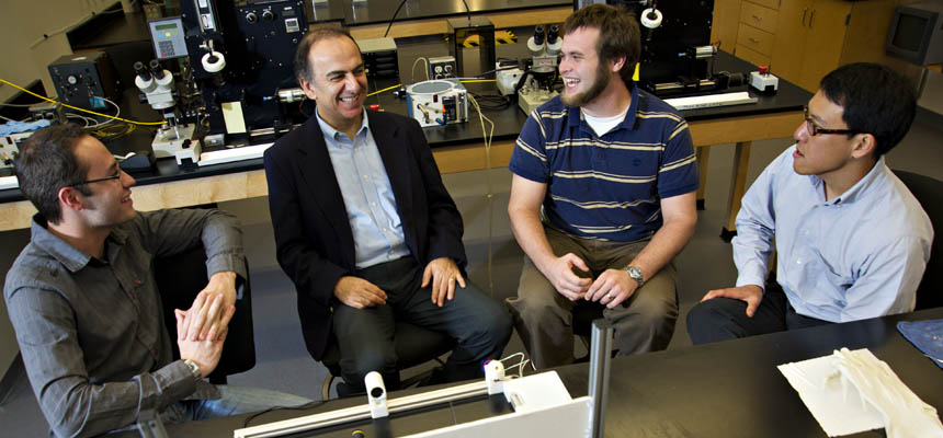 directors of the TEAM lab sit with two male students in the lab