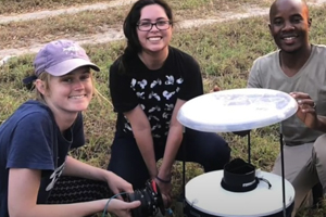 Three students around a mosquito trap