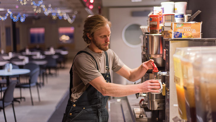 A man gets coffee from a dispenser