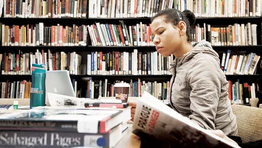 A woman reads a book in a library