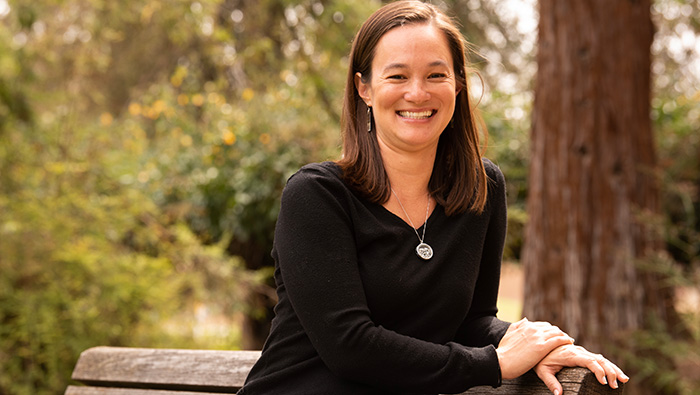 Woman sits outside on bench