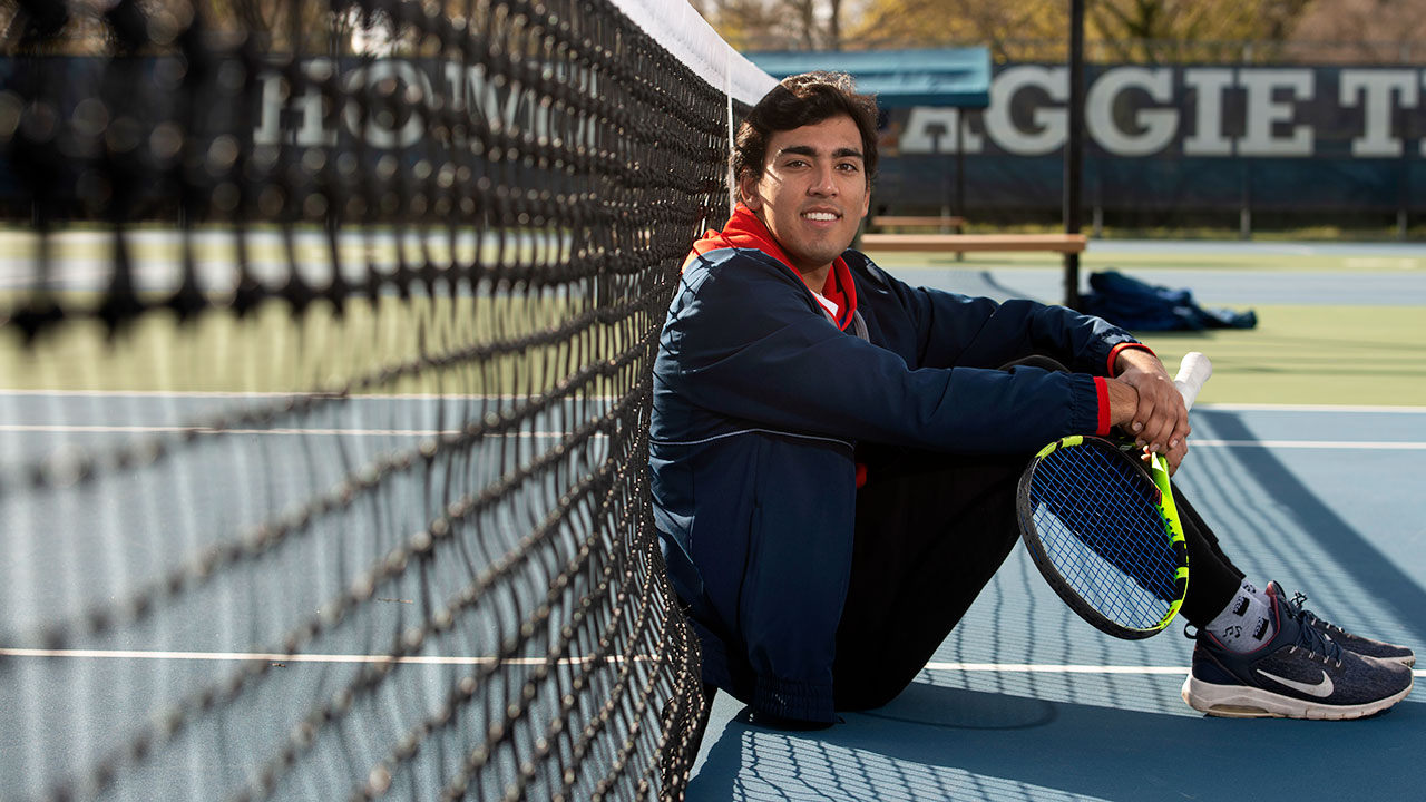 Chethan Swanson sits on the tennis court.