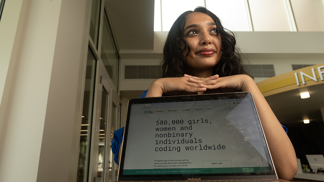 Nishi Bhagat seated with a laptop open in front of her