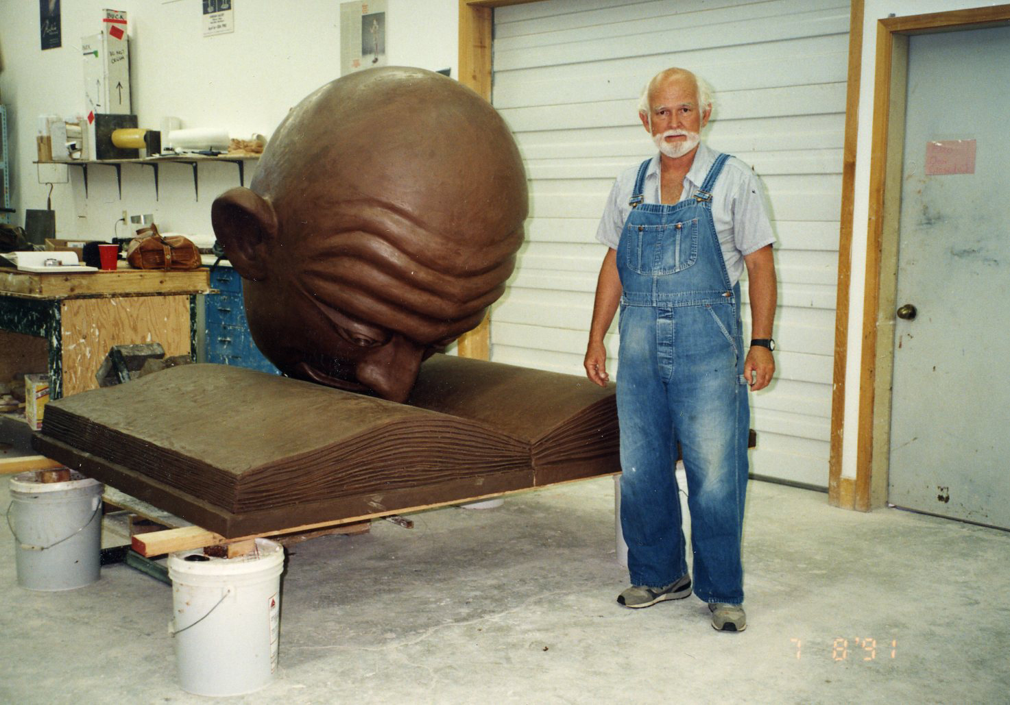 Robert Arneson Stands by the bronze Bookhead before it is installed. 