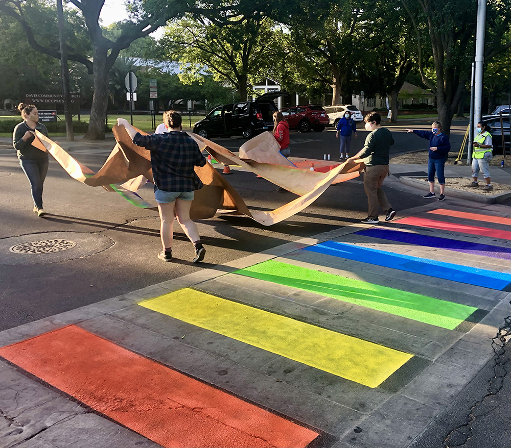 Rainbow stripes on street crosswalk.