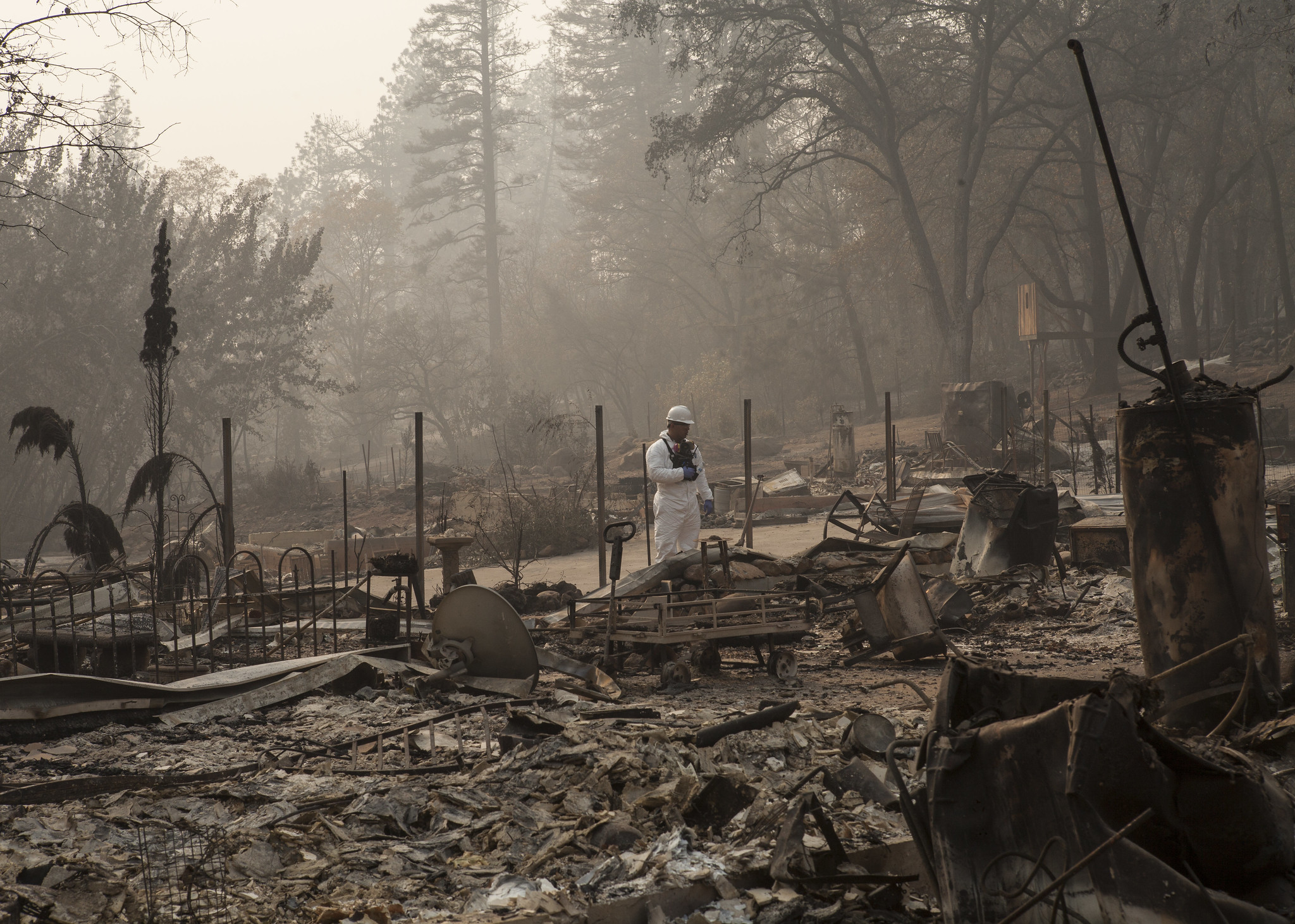 National Guard solder in white suit searches burned debris after 2018's Camp Fire in Paradise, California
