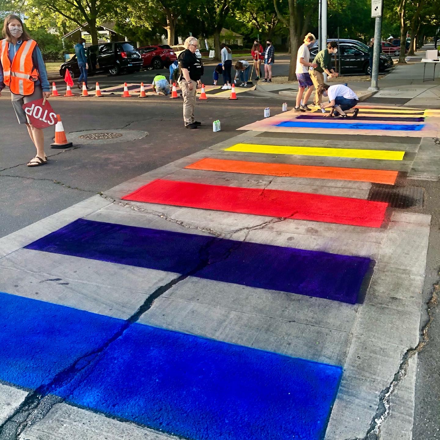 Pride Month Rainbow crosswalk. Shows stripes of blues, reds, oranges and yellow.