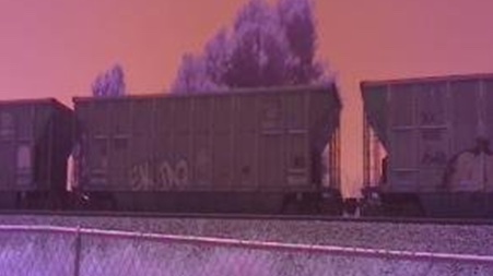 purple-tinged color highlights passing coal train shot with scientific monitoring device