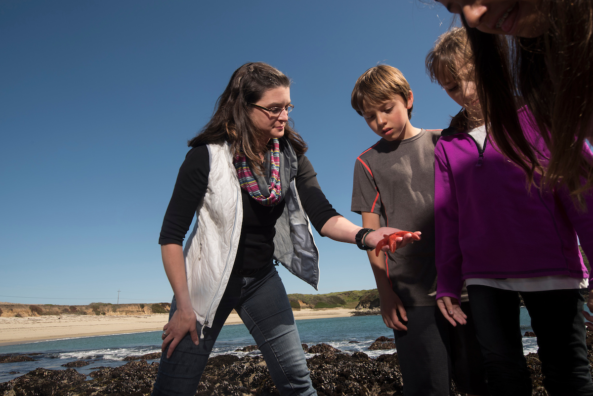 Tessa Hill with children outside with Bodega Bay in background