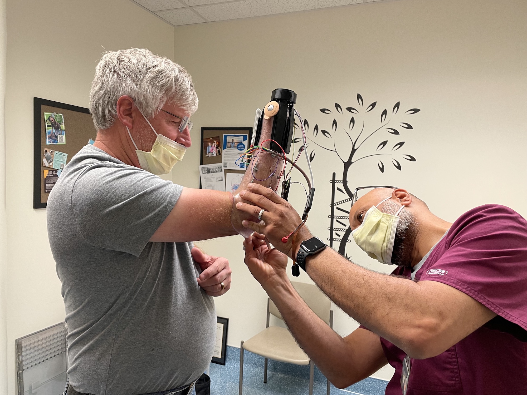 Fehran Maher, a certified prosthetist with UC Davis Health, checks the fitting of the prosthetic sleeve for David Brockman, a retired firefighter and amputee.