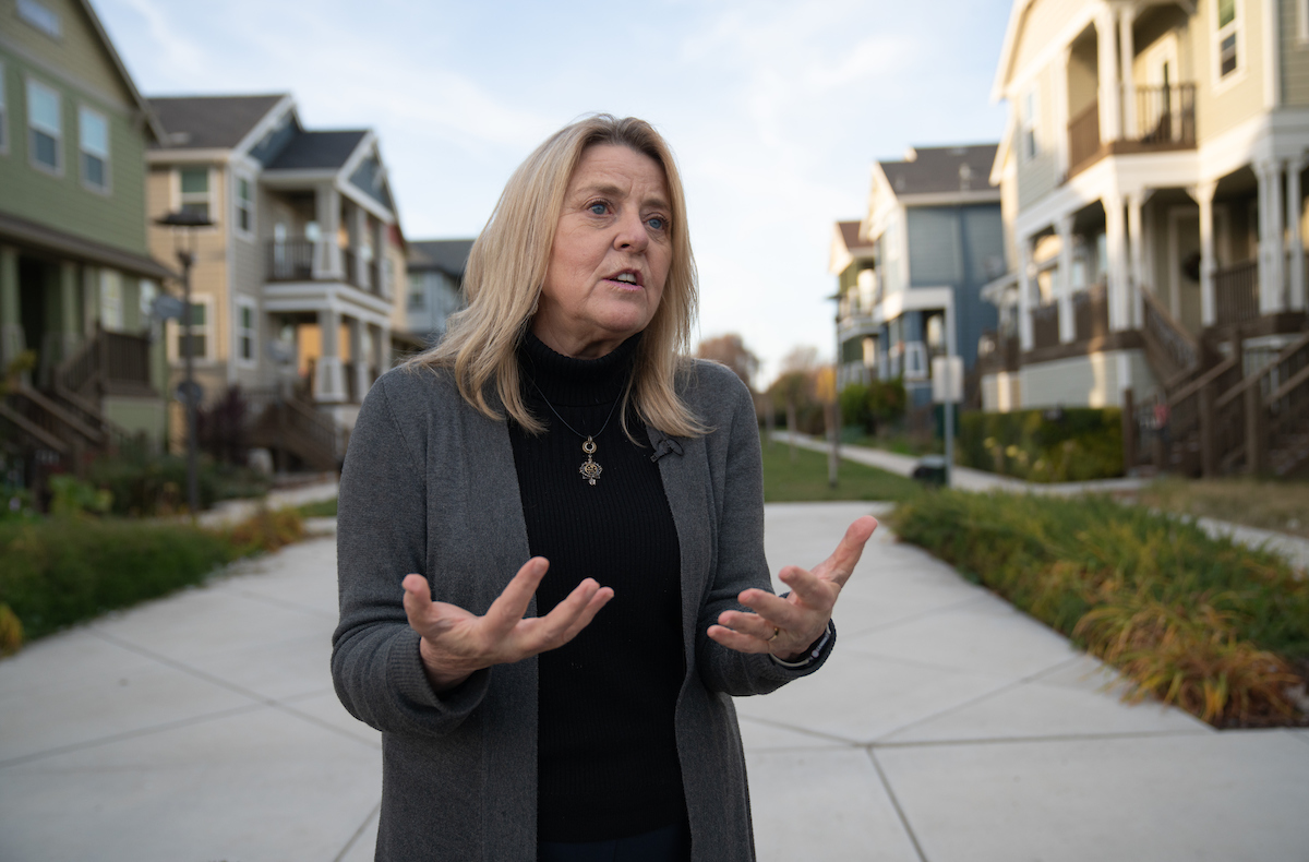 Kathleen Schaefer of UC Davis talks in front of elevated houses