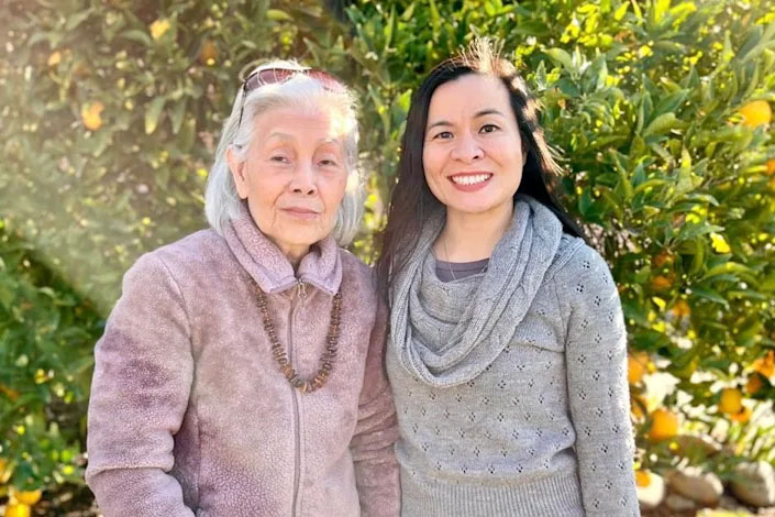 Oanh Meyer, a social psychologist at the Alzheimer's Disease Center at UC Davis Health, stands next to her mother, a former Vietnamese refugee, who now has dementia.