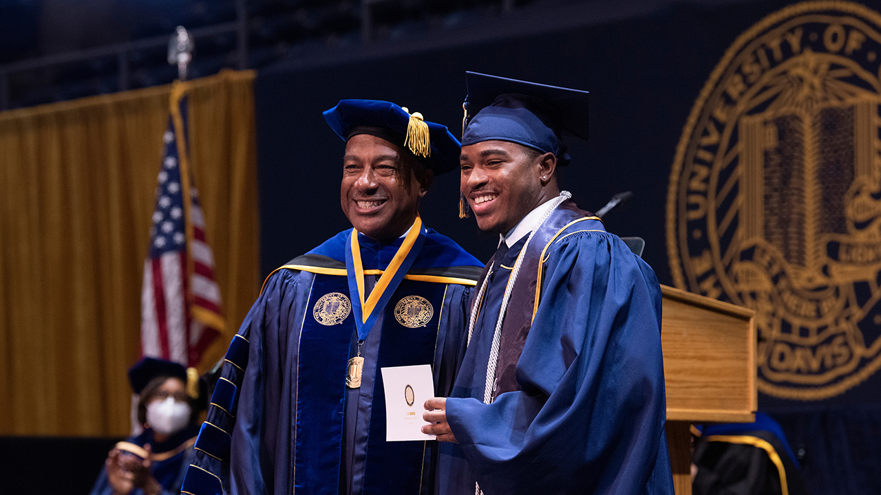 Chancellor Gary S. May poses with Evan Pearson on the graduation stage
