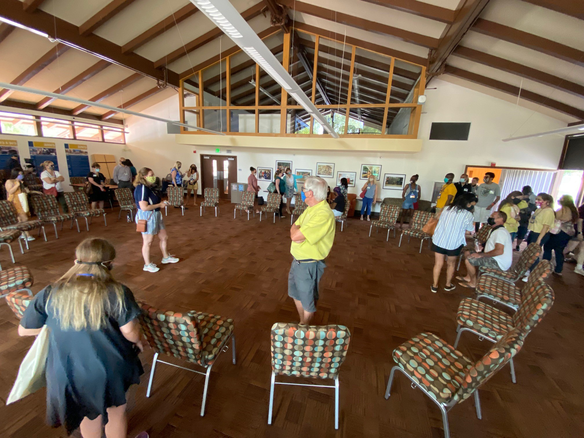 A group of people look around a large room with chairs set up in a circle