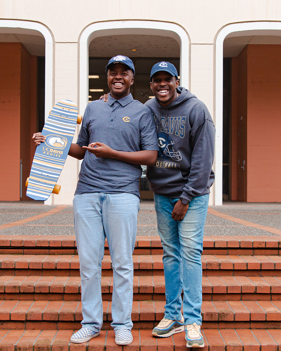 Two people pose for photo on Mrak Hall stairs.