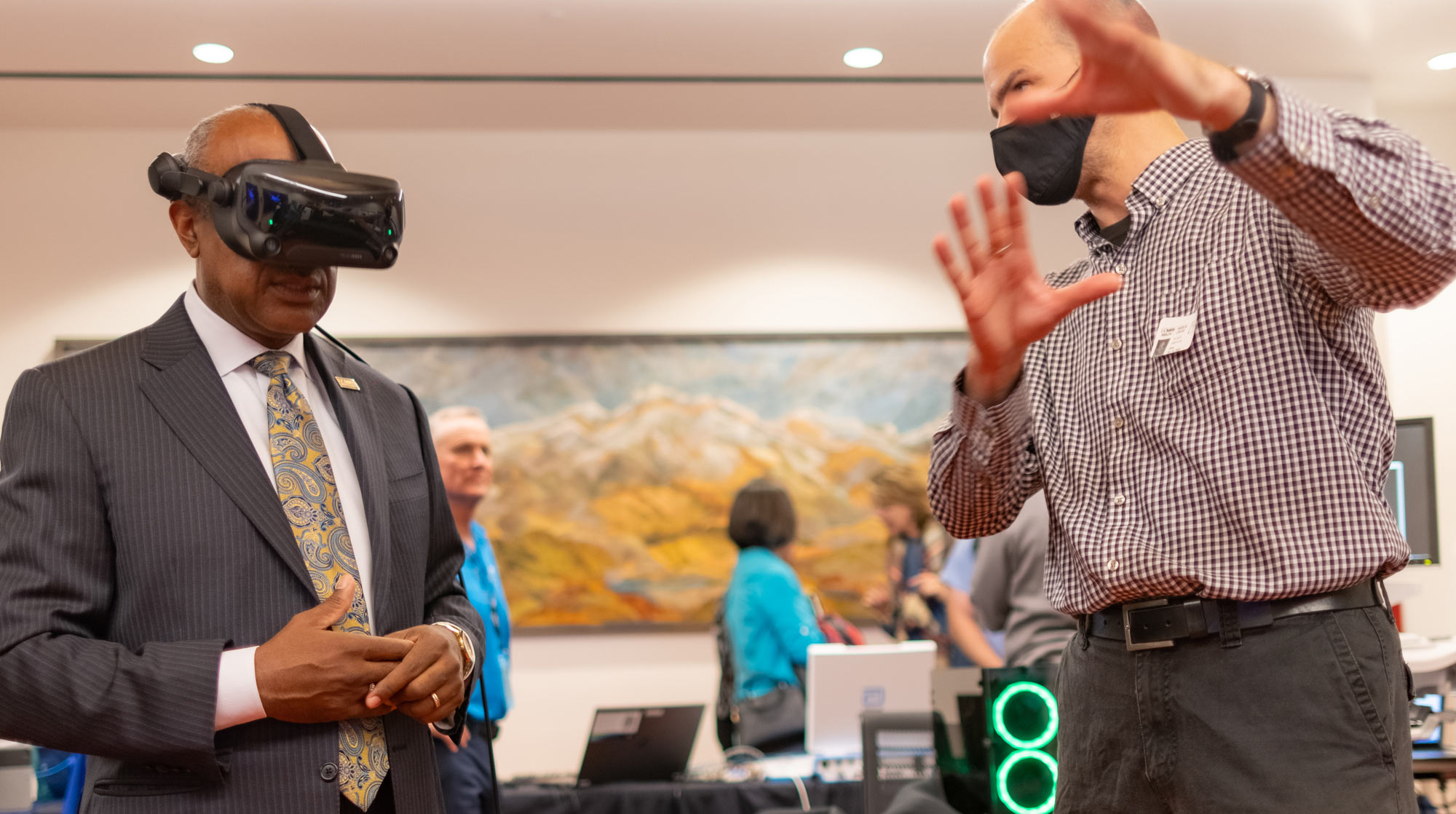 Chancellor Gary S. May, in face mask, wearing virtual reality headset