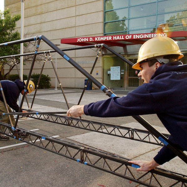 Students build an iron bridge outside of the Engineering complex at UC Davis
