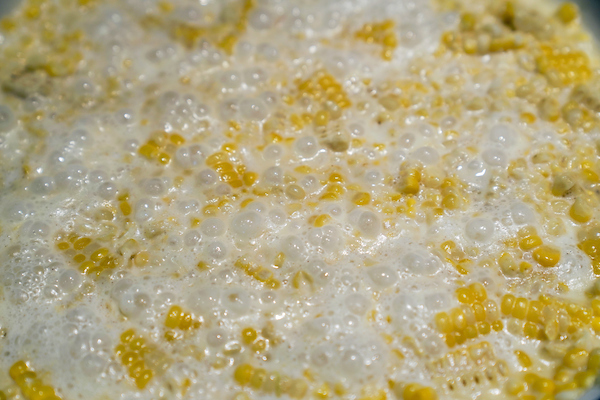 Corn that's been creamed bubbles over the stove
