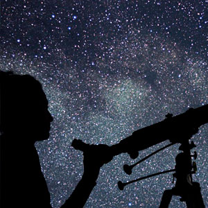 a silouhette of a person looking at a night sky through a telescope