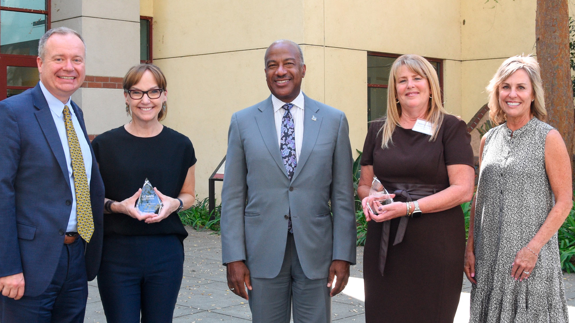 Award recipients (2) and UC Davis executives, posed, in a line