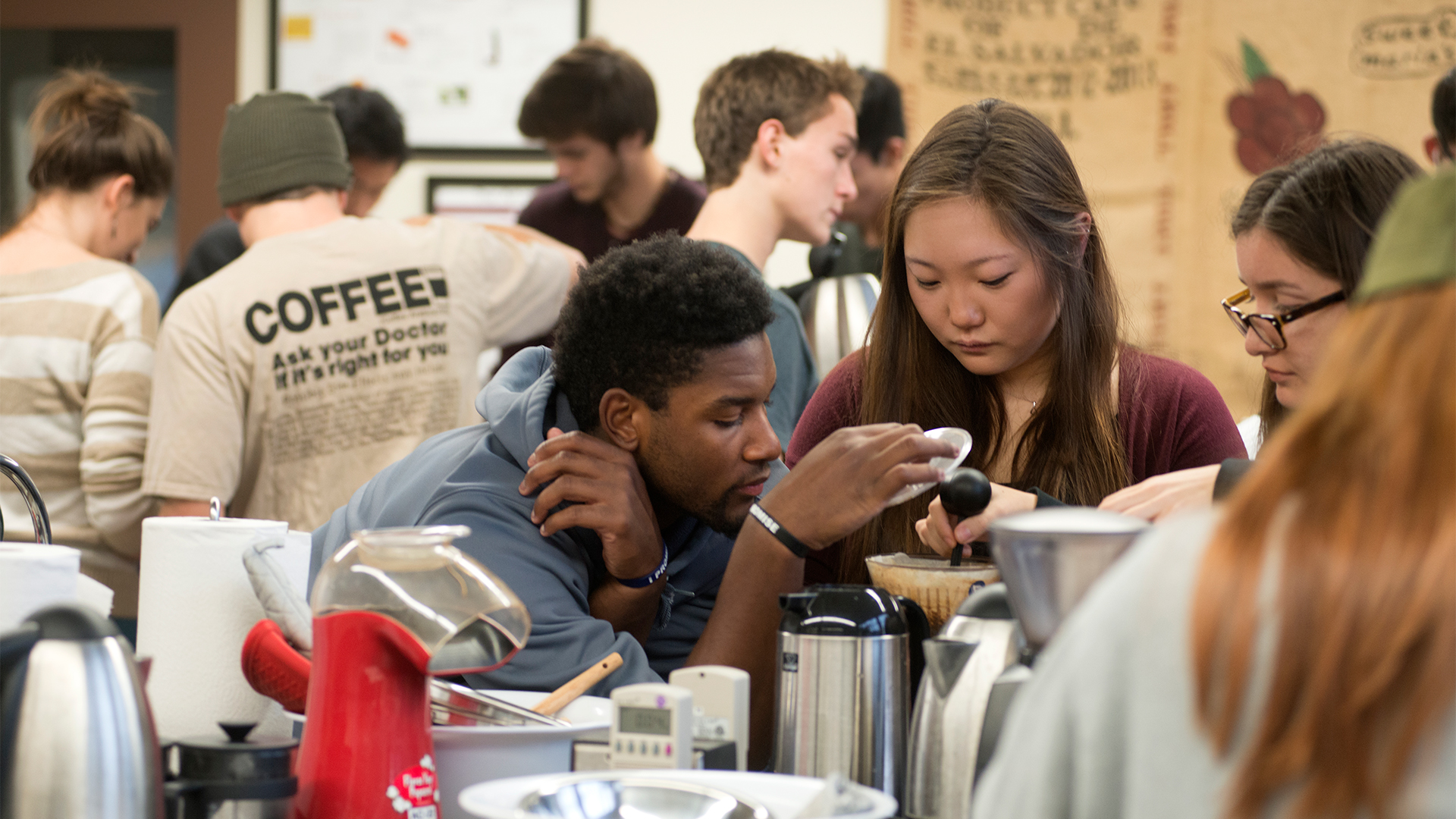 Student groups in the Design of Coffee class work intensely on their final projects for the coffee tasting competition.