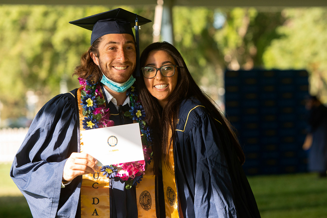 Two people pose for a photo at commencement.