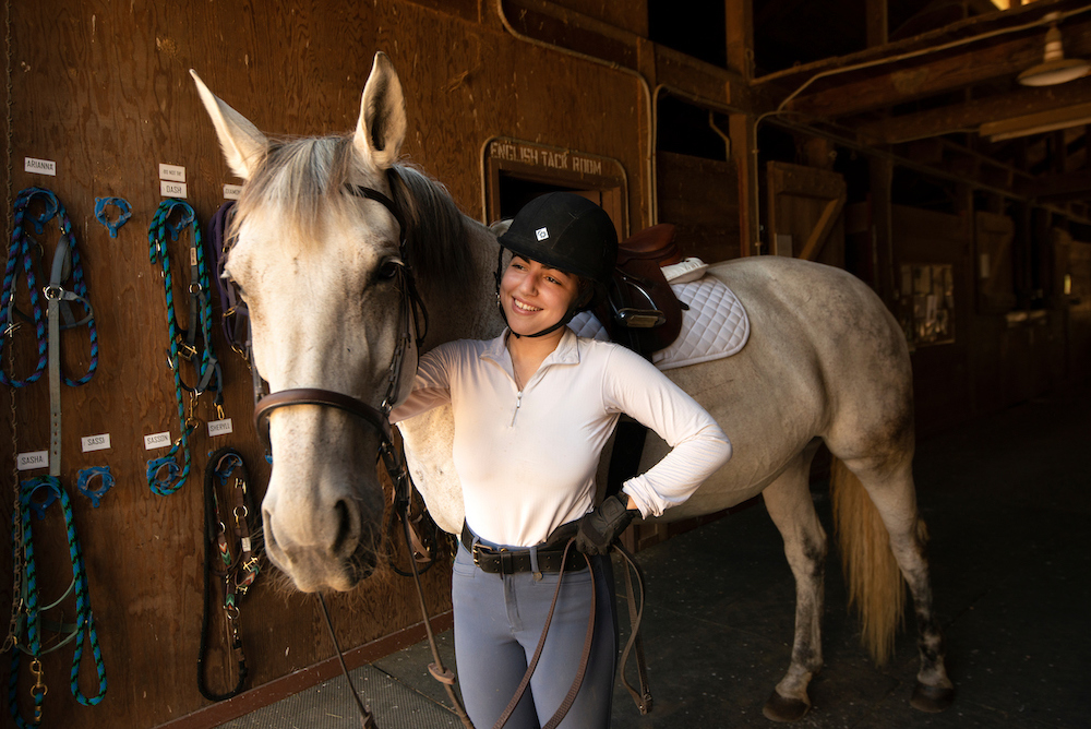 A student guides her horse at UC Davis. 