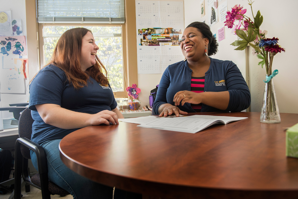 A student laughs with an advisor at UC Davis. 