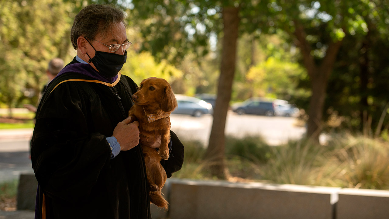 Dean Kevin Johnson carries dog