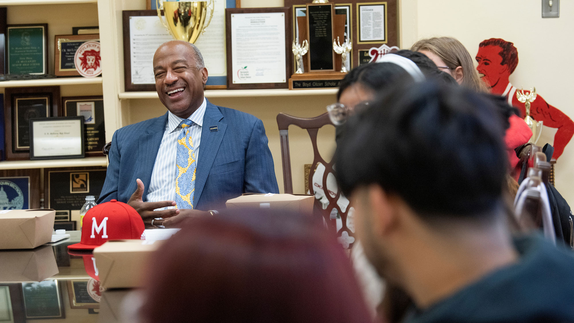 Chancellor Gary S. May seated at a table with high school students