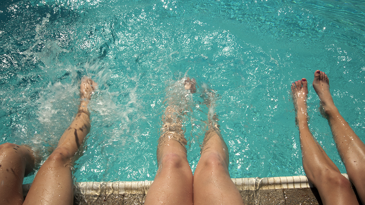 Close up of students dipping their legs in at the Rec Pool.