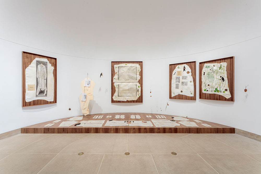 artwork in museum installation on white walls and beige floor