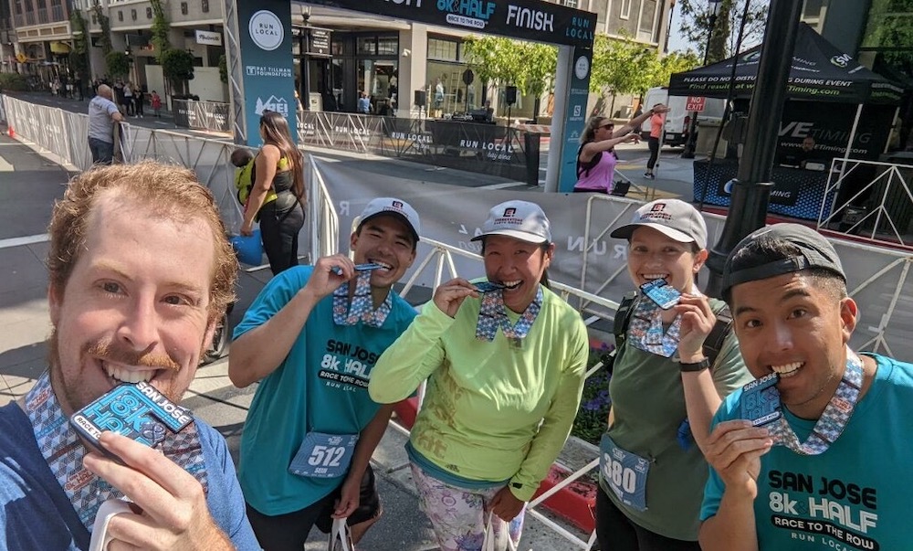 Five runners hold up their souvenirs after a marathon. 