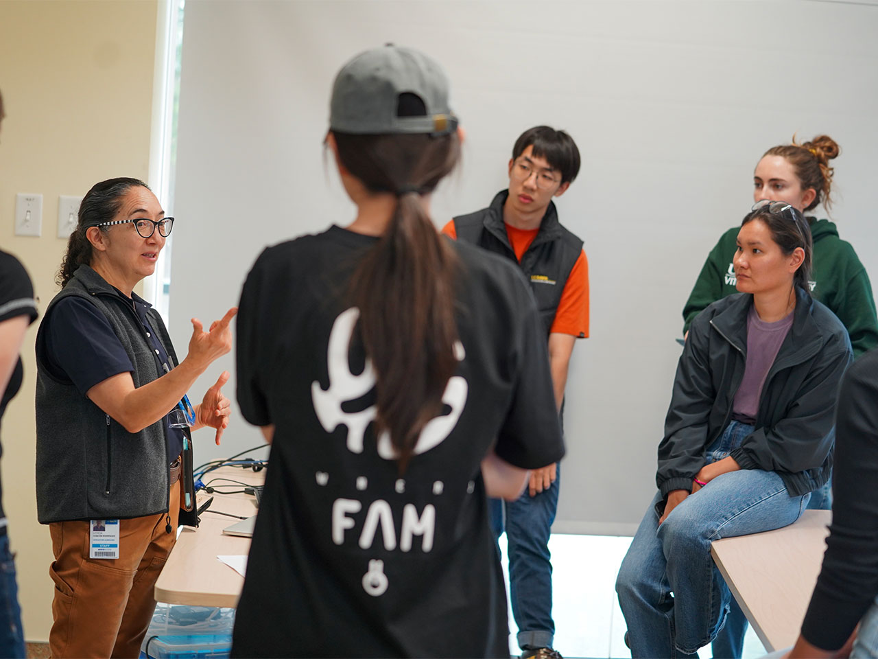 Leticia Chacón-Rodríguez chats with a group of students around her in a classroom.