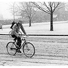 A bicyclist rides through the snow.