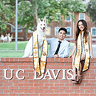 Two students posing with a dog