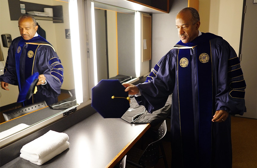 Gary S. May prepares backstage before the investiture.