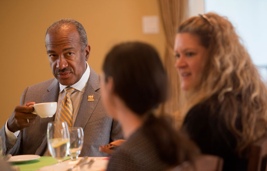 Chancellor Gary May, holding cup of coffee