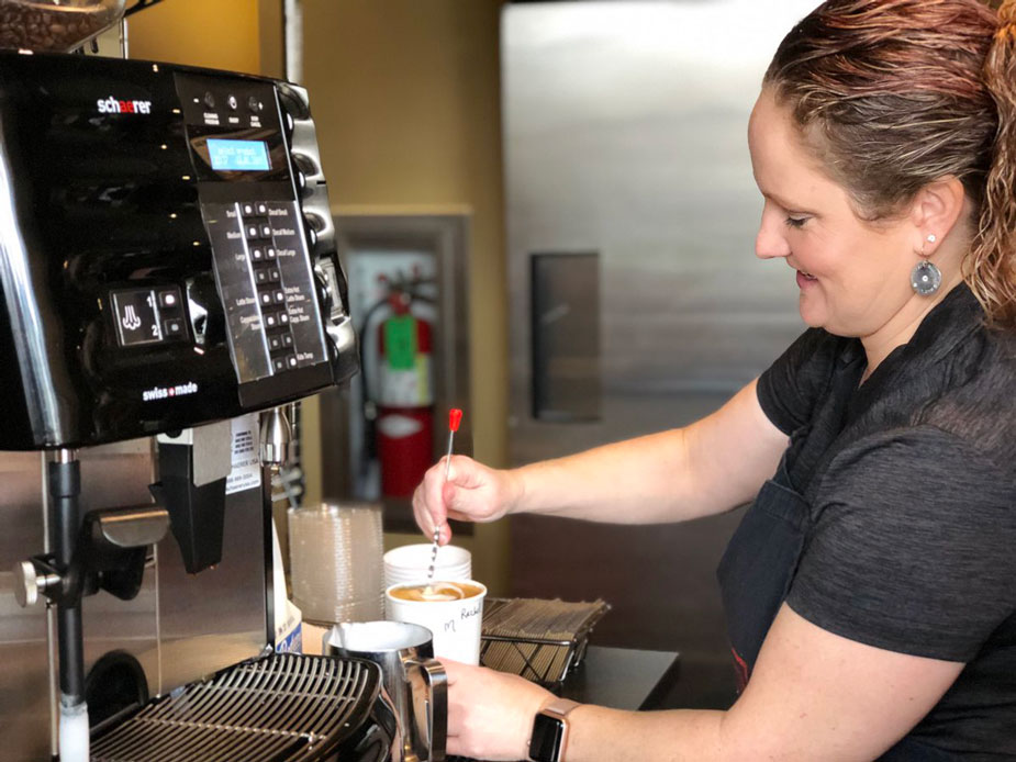 Barista makes espresso drink.