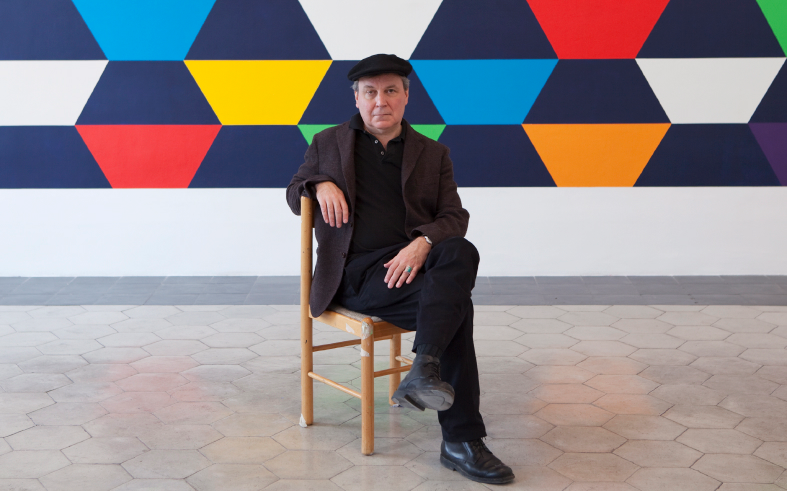 Stephen Westfall, seated in front of geometric painting