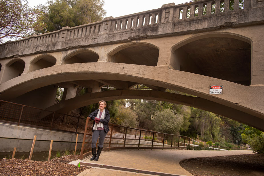 Christina De Martini Reyes poses under old bridge.