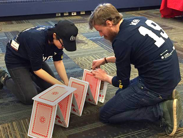 Students build house of cards with giant cards.